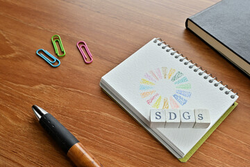 A cube of letters the SDGs stamped on it is placed with the symbol of the SDGs.