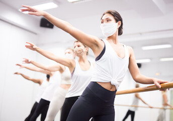 Ballet troupe in protective masks rehearses in a ballet class