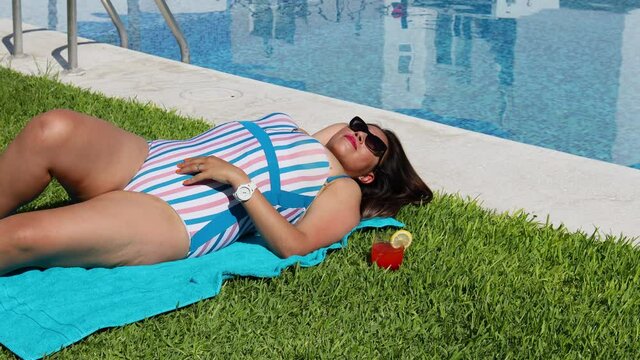 Mexican curvy woman taking sunbath near the pool