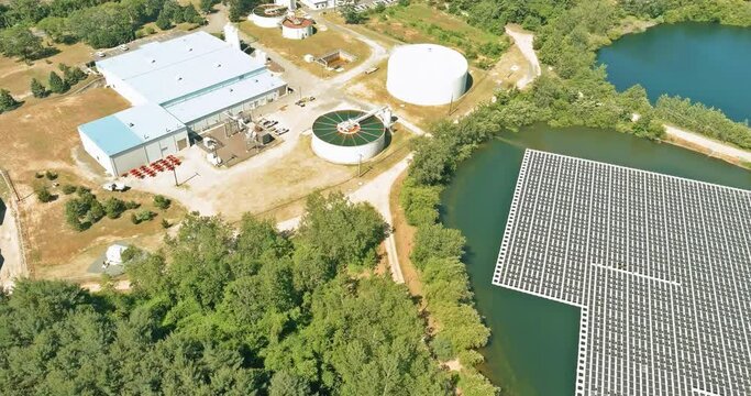 Aerial view of solid clarifier tank type sludge recirculation in water treatment plant in ner the floating solar panels cell platform on lake