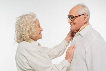 elderly woman gently touching senior man with hand isolated on white