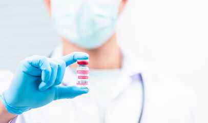 Obraz premium scientist in uniform wearing a face mask showing up coronavirus vaccine