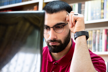 Arabic man using a laptop during conferences or meetings for studying and teaching through online channels