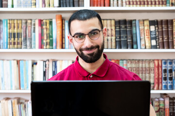 Arabic man using a laptop during conferences or meetings for studying and teaching through online channels