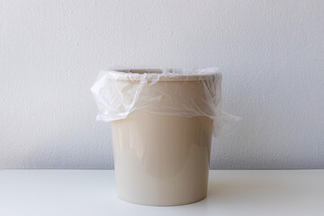 Empty trash container or bin with white plastic bag