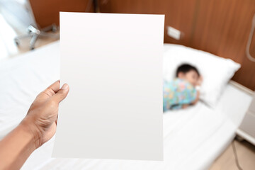 Healthcare health insurance concept. Parent looking at invoice or receipt paper document from hospital payment department expenses of ill kid patient