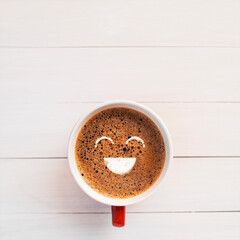 froth milk foam smiles in a cup of coffee in morning.