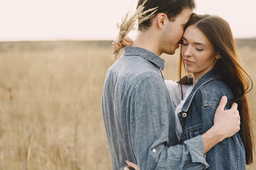 Happy couple in love in wheat field at sunset