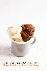 Ice cream scoops in cones on white wooden background.