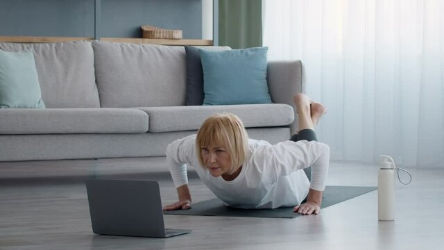 Senior Female Doing Push Ups Exercising At Laptop At Home