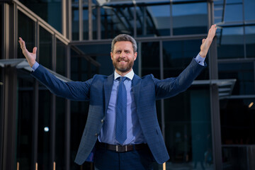 Successful amazed businessman near office buildings. Business man excited portrait.