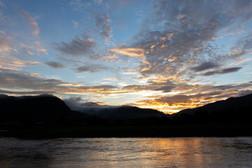 landscape river mountain sky orange clouds sunset evening mountain silhouette for refreshing background