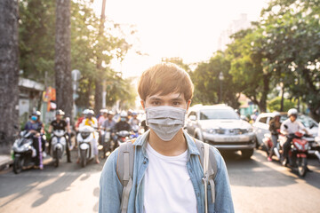 Tourist man with mask having a coffee while walking on street, travel concept in the new normal