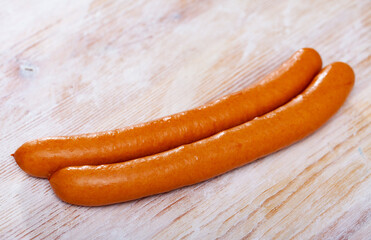 Appetizing thin sausages on wooden background. Traditional Czech meat product..