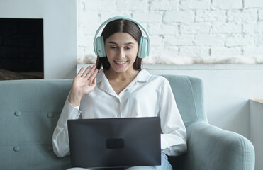 Happy young woman talking to web camera during remote online distance video call.