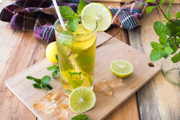 herbal healthy drinks cold lemon for health care with peppermint leaf and lemon slice on background wooden