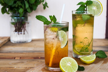 herbal healthy drinks cold lemon tea for health care with peppermint leaf and lemon slice on background wooden