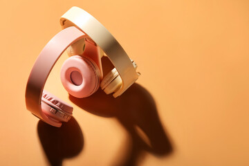 Modern headphones on color background