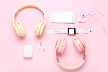 Modern headphones, earphones, mobile phone and smart watch on color background
