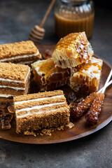 Honey cake slices and honeycomb on  dark background