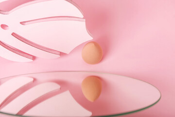 Makeup sponge and mirror on color background