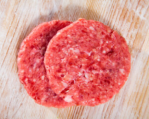 Cooking ingredients, raw burger patties on wooden table