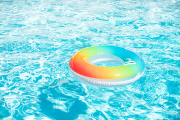 Pool float, ring floating in a refreshing blue swimming pool on summer background.