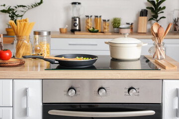 Obraz na płótnie Canvas Modern electric stove and utensils in kitchen