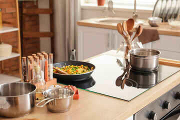 Modern electric stove and utensils in kitchen