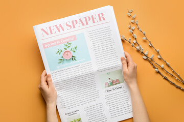 Fototapeta premium Woman with newspaper and willow branches on color background