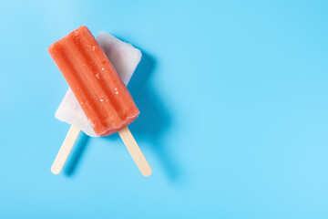 top view fresh red popsicle and white popsicle on a blue background