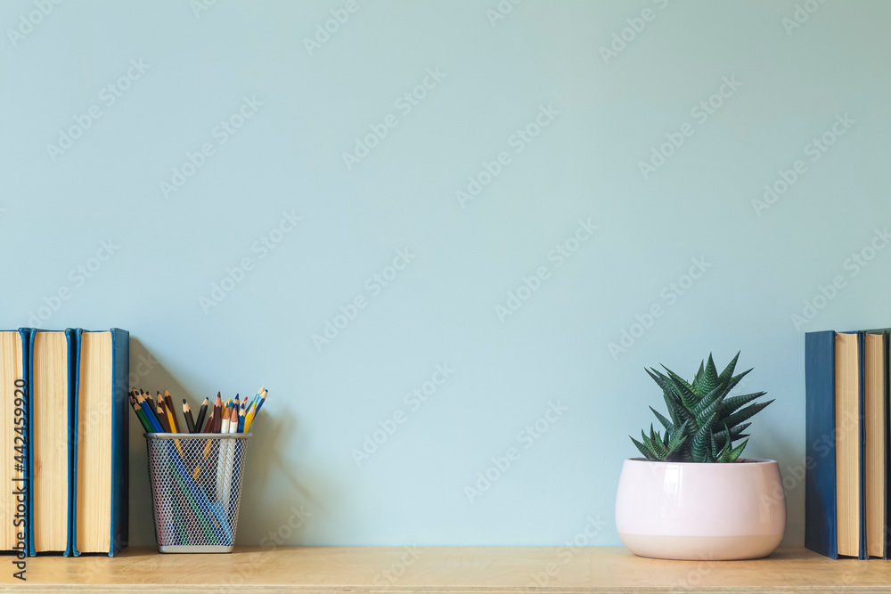 Wall mural home office desk table background. empty wall with wooden table with stationery and books for work o