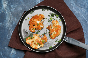 Frying pan with tasty fried cauliflower on color background