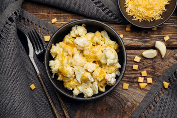 Bowl with tasty cauliflower and cheese on wooden background
