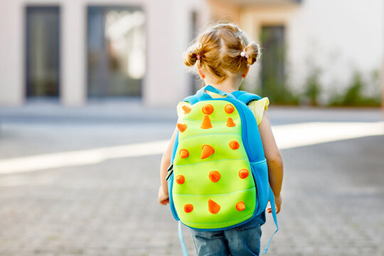 Cute Little Adorable Toddler Girl On Her First Day Going To Playschool. Healthy Beautiful Baby Walking To Nursery School And Kindergarten. Happy Child With Backpack, Unrecognizable Face.