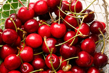 Basket with tasty ripe cherry on table, closeup