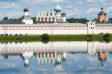 Fototapeta premium Ancient belfry in the complex of buildings of the Tikhvin Theotokos Assumption Monastery on July afternoon. Leningrad region, Russia