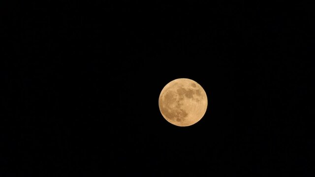 Full moon closeup slides on a night sky background. Real life footage