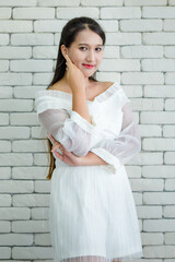 Smiling elegant woman in dress on brick wall background