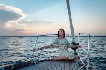 Joyful woman middle age portrait on deck of sailing yacht enjoying water trip