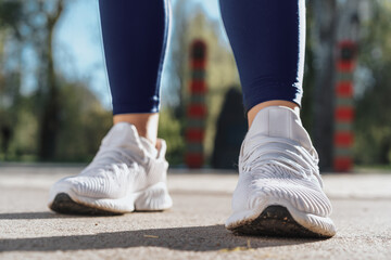 Fototapeta na wymiar Feet of a woman dressed in sportswear and sneakers for running