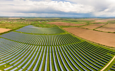 Aerial view of big sustainable electric power plant with many rows of solar photovoltaic panels for...