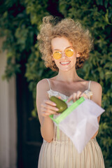 A picture of a young woman with an avocado in her hand