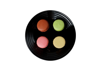 set of multi-colored macarons on a black plate. sweets are in trend. View from above. Copy space.