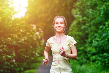 Young fitness woman running at forest trail.