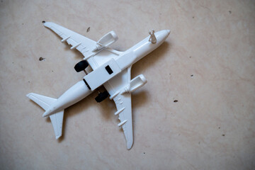 white toy airplane with black wheels lying on ceramic