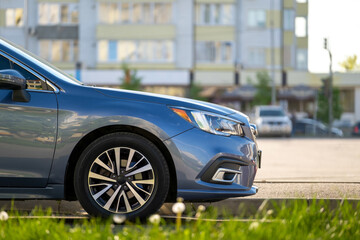 Car parked on a city street side with blurred urban traffic.