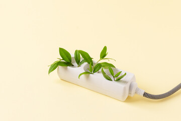 White plug  with green plant as a concept of eco energy. Creative idea of eco alternative energy.
