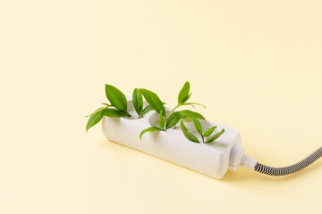 White plug  with green plant as a concept of eco energy. Creative idea of eco alternative energy.