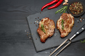 Grilled roated beef steaks on stone serving cutting board